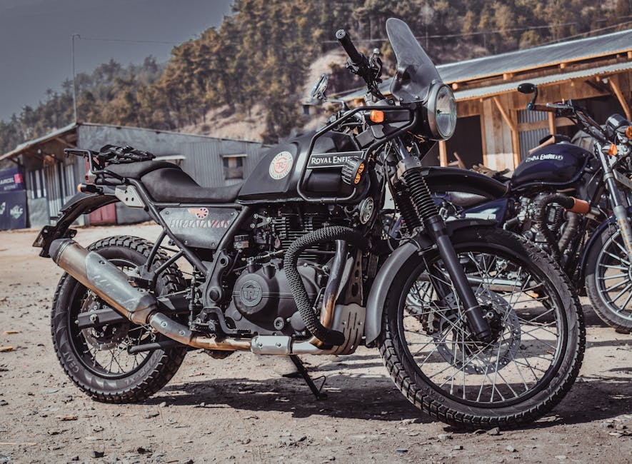 A Royal Enfield Himalayan motorbike parked outdoors in a rural Indian setting.